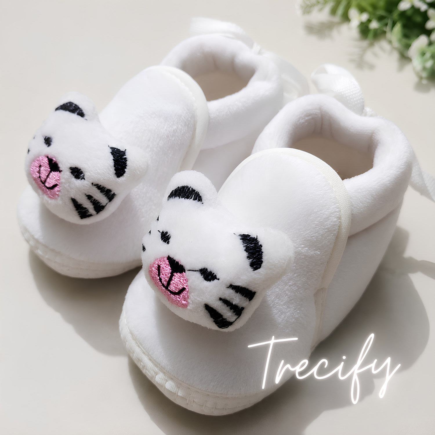 White baby slippers with cat face design on a light background, featuring the brand 'Trecify'.